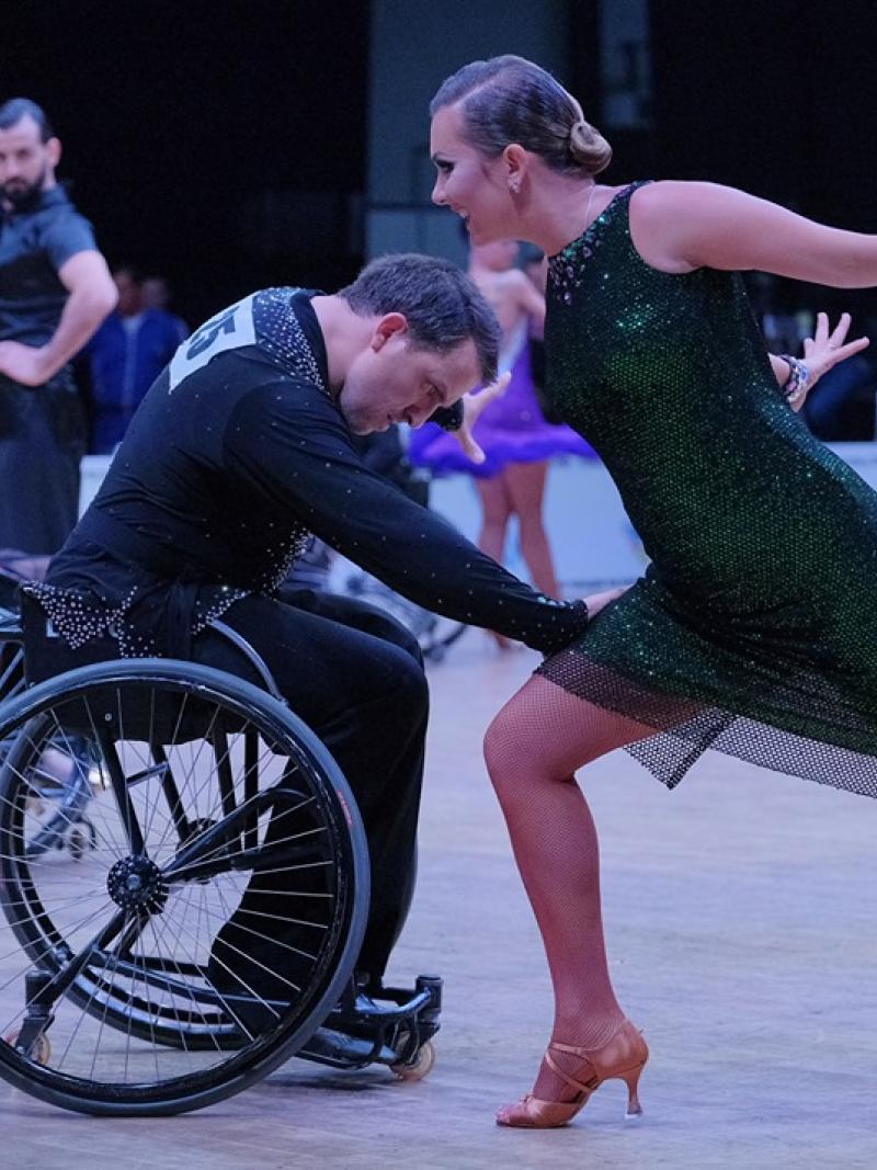 Man in wheelchair dancing with standing partner