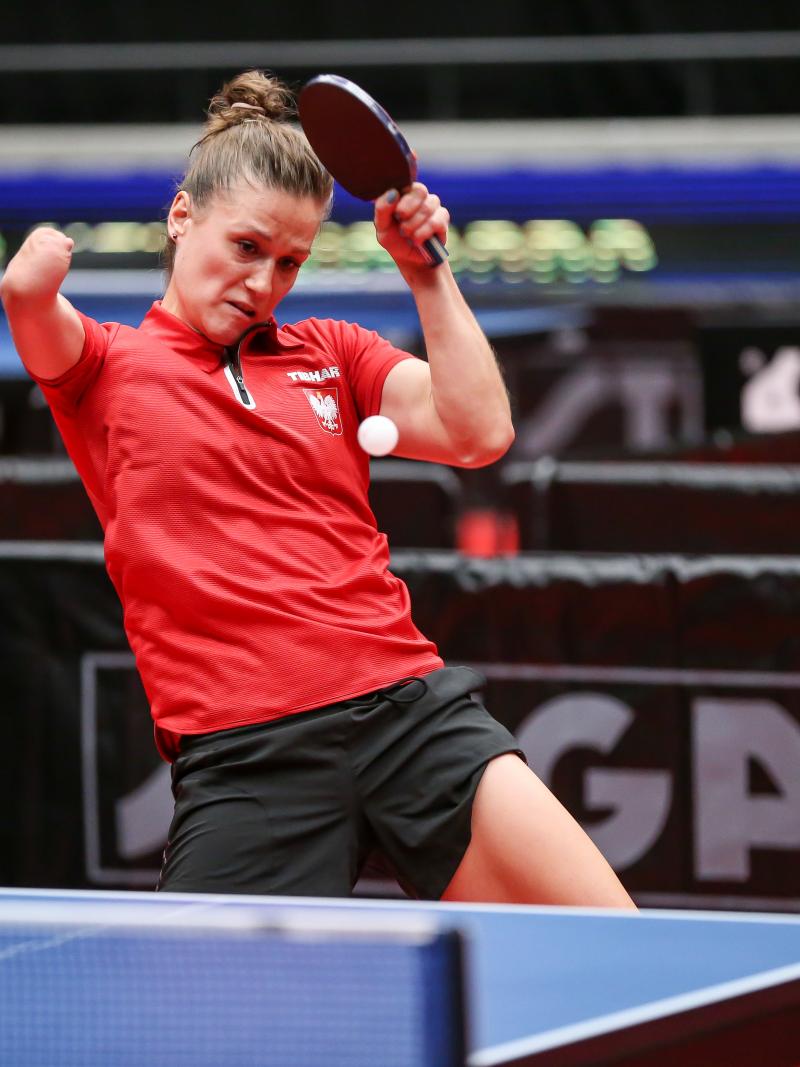 Woman with right arm impairment hits return shot in table tennis