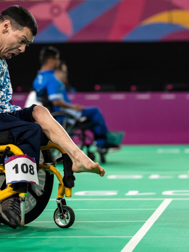 Argentinian boccia player throws the ball with his foot