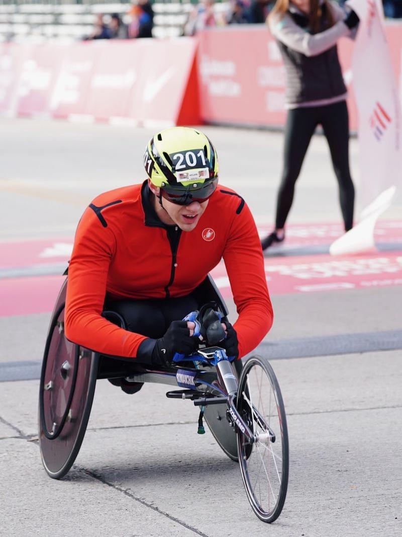 A man in a wheelchair race crossing the finish line of the Chicago Marathon