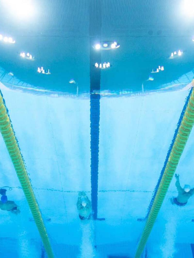 An underwater image of four men swimming in a pool