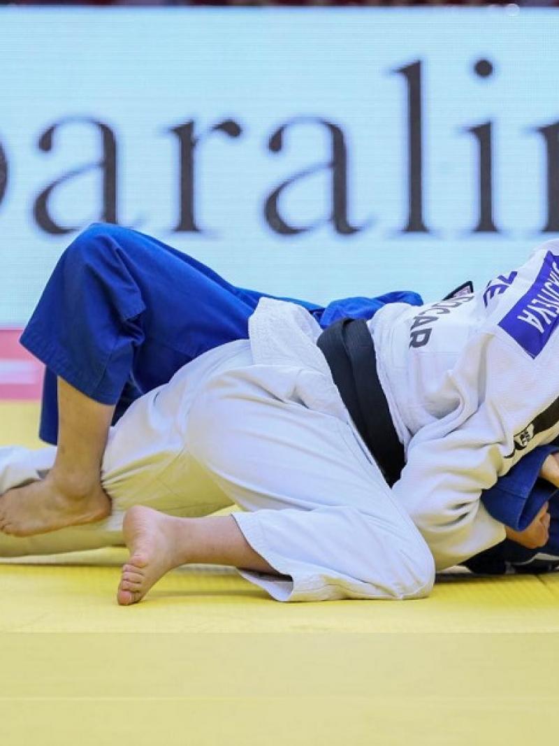 Azerbaijani judoka Shahana Hajiyeva holds her rival on the floor and smiles as she beats her