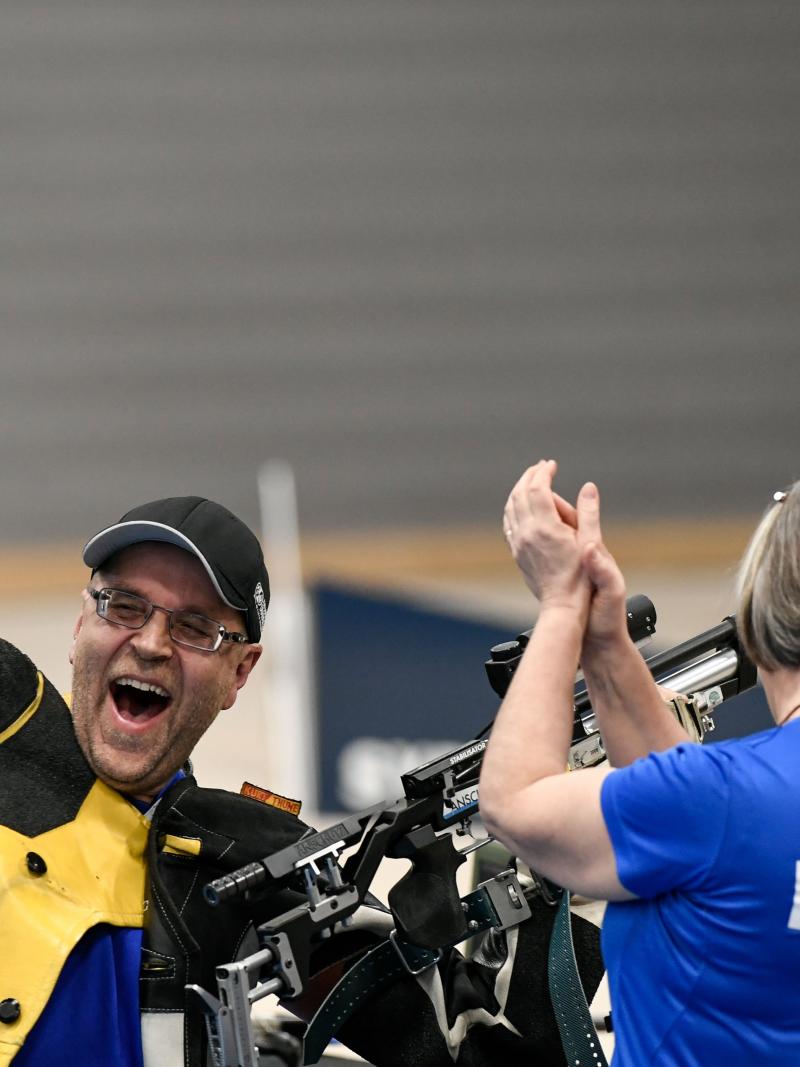 A male shooter celebrating together with a woman with a shirt written Finland