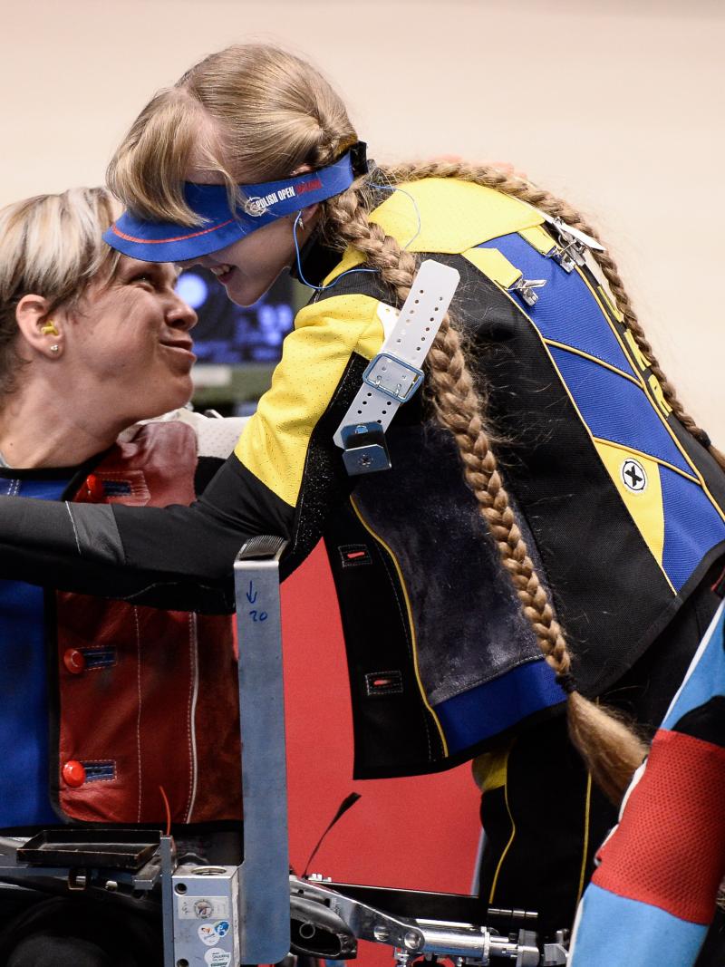 Two female shooters hugging