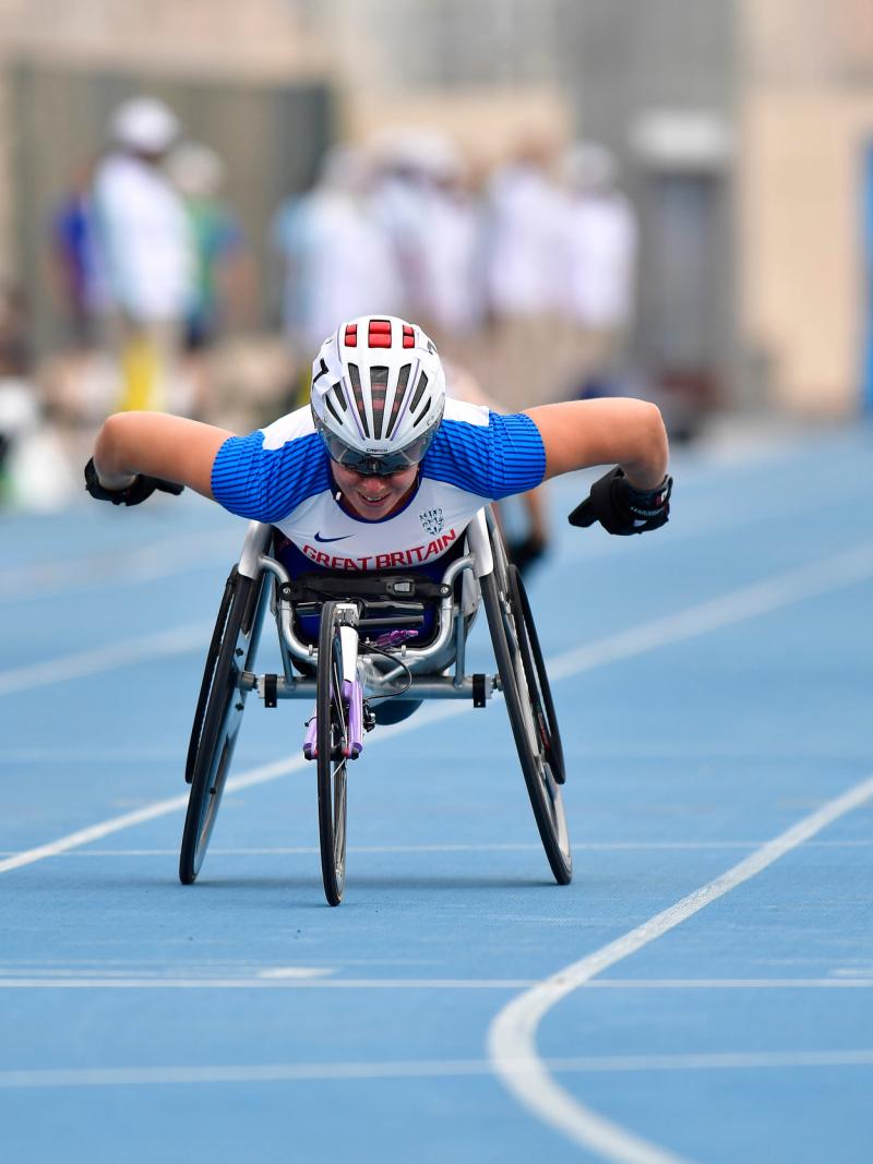 A female wheelchair racer crossing the line ahead of two other competitors