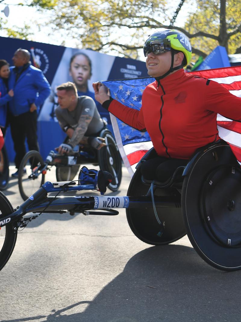 Daniel Romanchuk holds the US flag after winning the 2019 New York Marathon