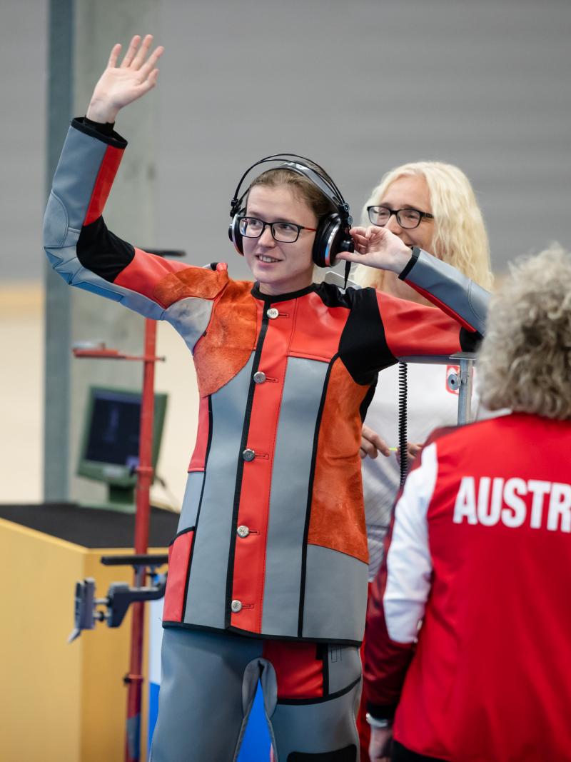 Female vision impaired shooter waves at audience