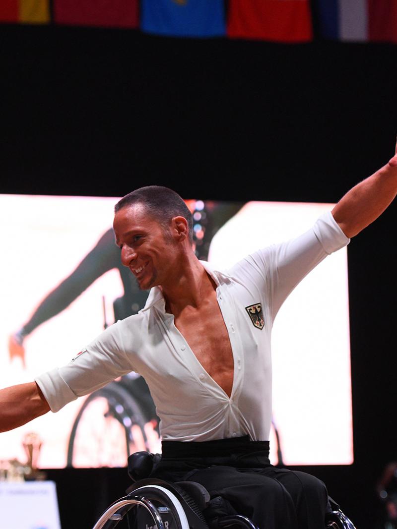 German male dancer spreads arms during performance