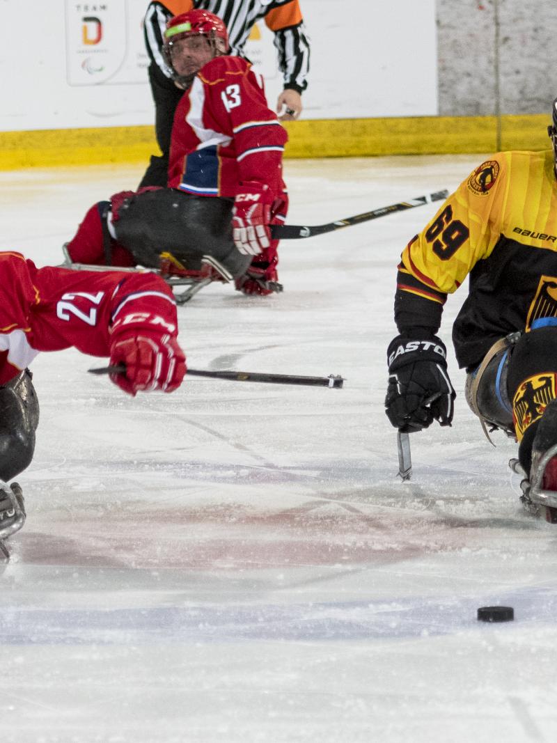 Two ice hockey players go for the puck