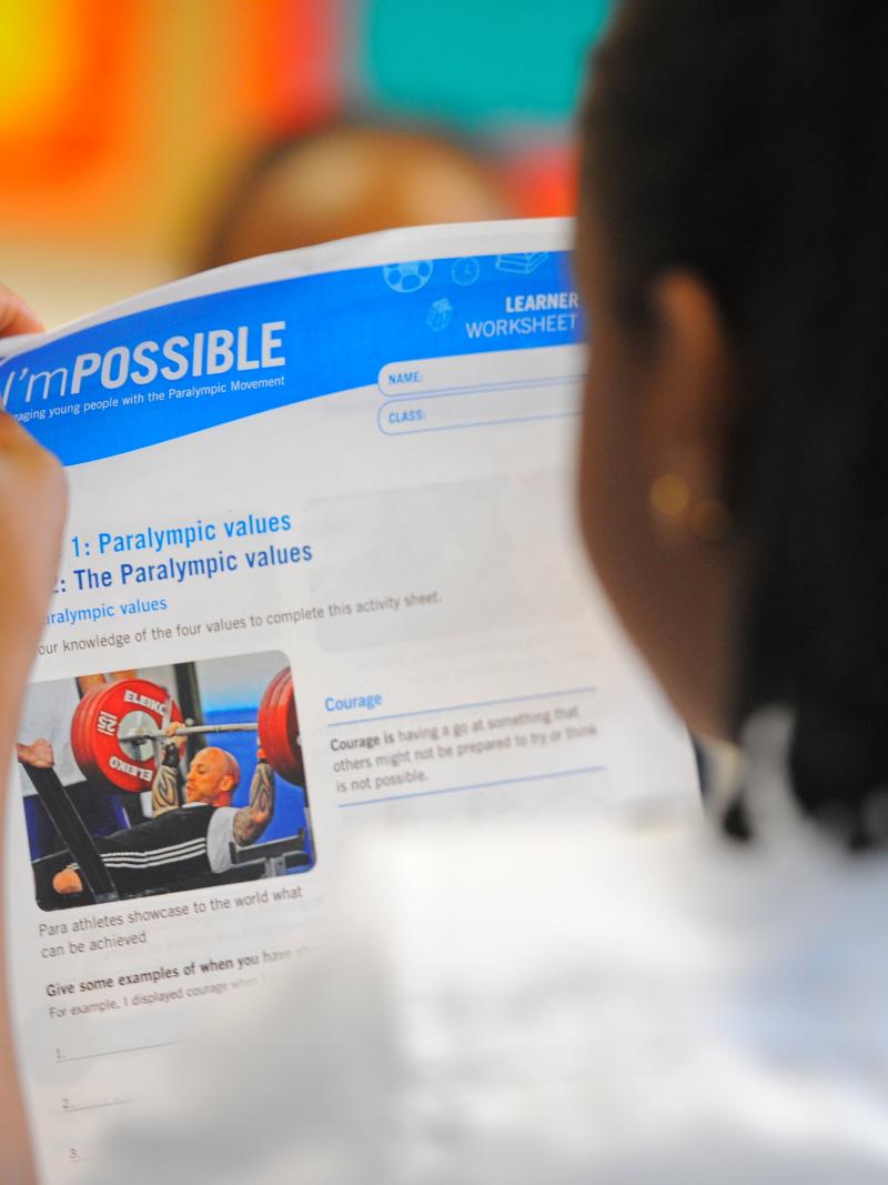 Girls read I'mPOSSIBLE education programme materials