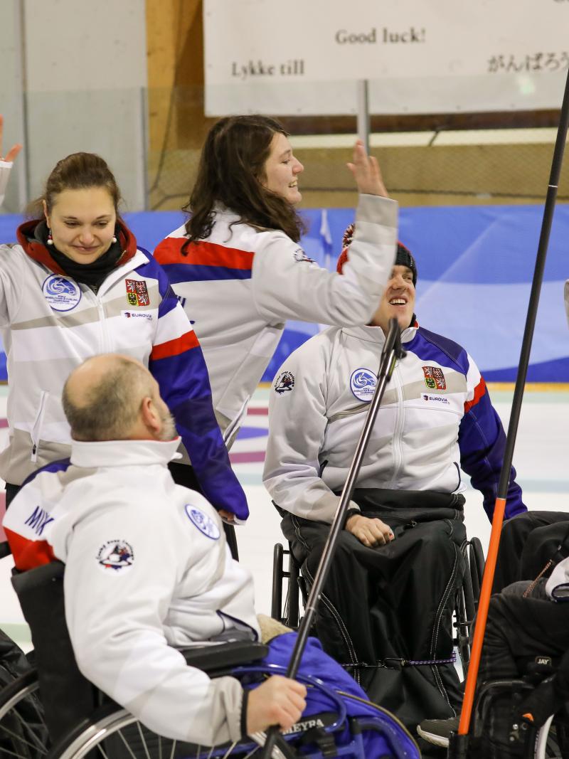Group of Czech Republic wheelchair curlers high five each other