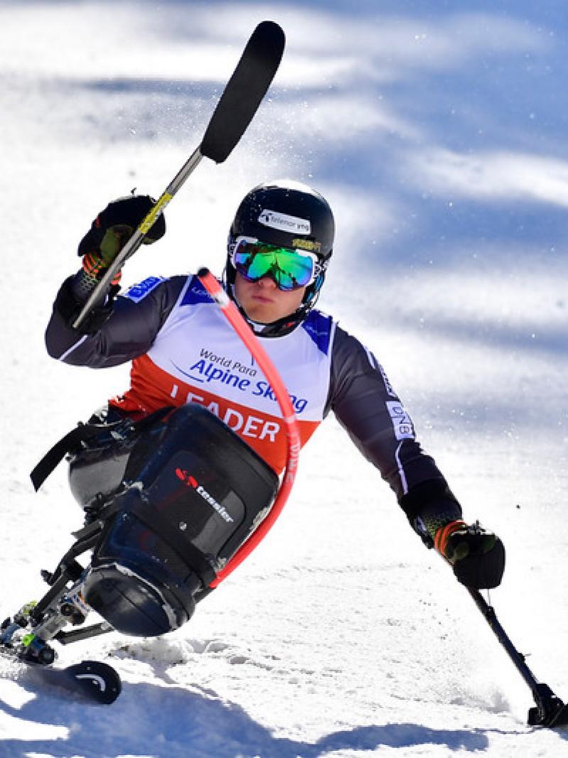 A male sitskier competing in the snow