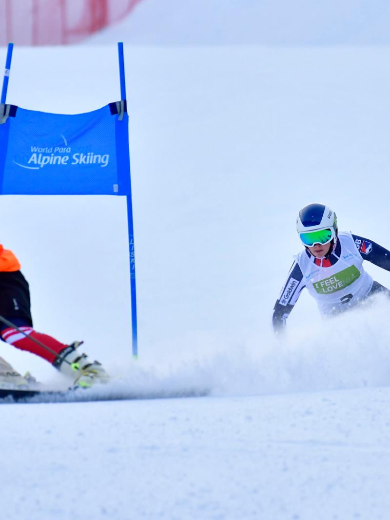 A female Para alpine skier behind her guide