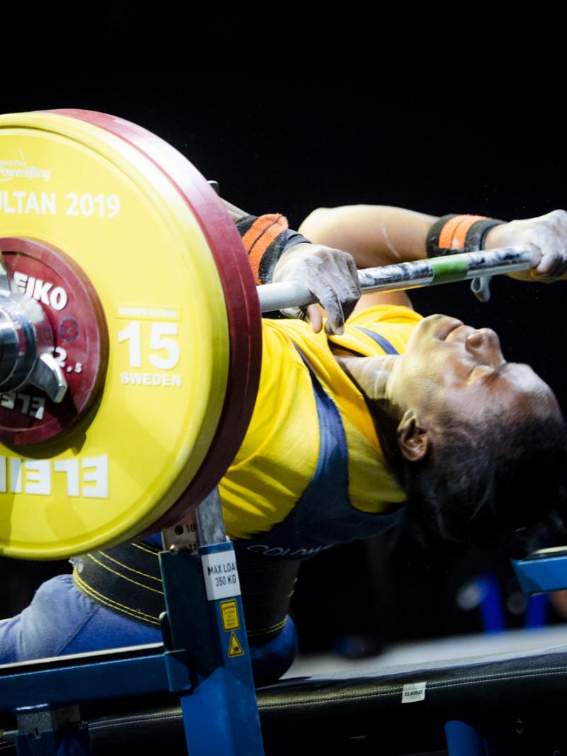 Female powerlifter holds onto the bar preparing for her lift