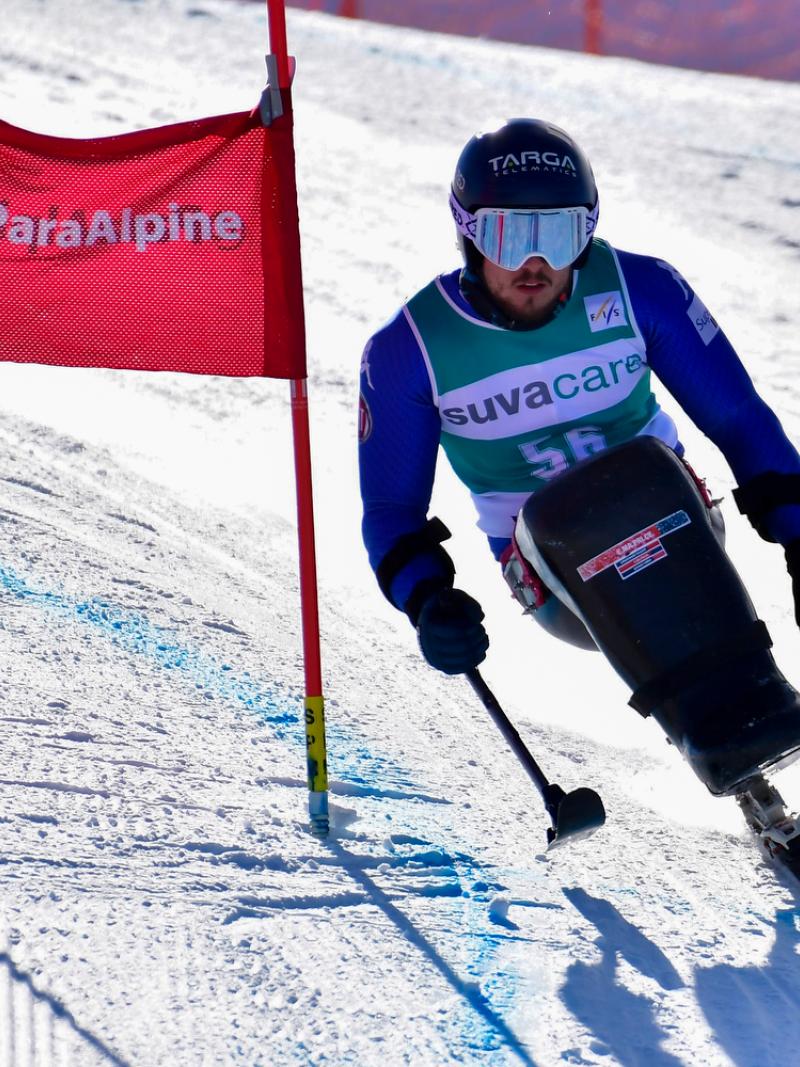 Male sit skier rides down mountain