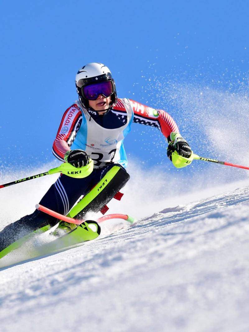 Male standing skier makes a turn