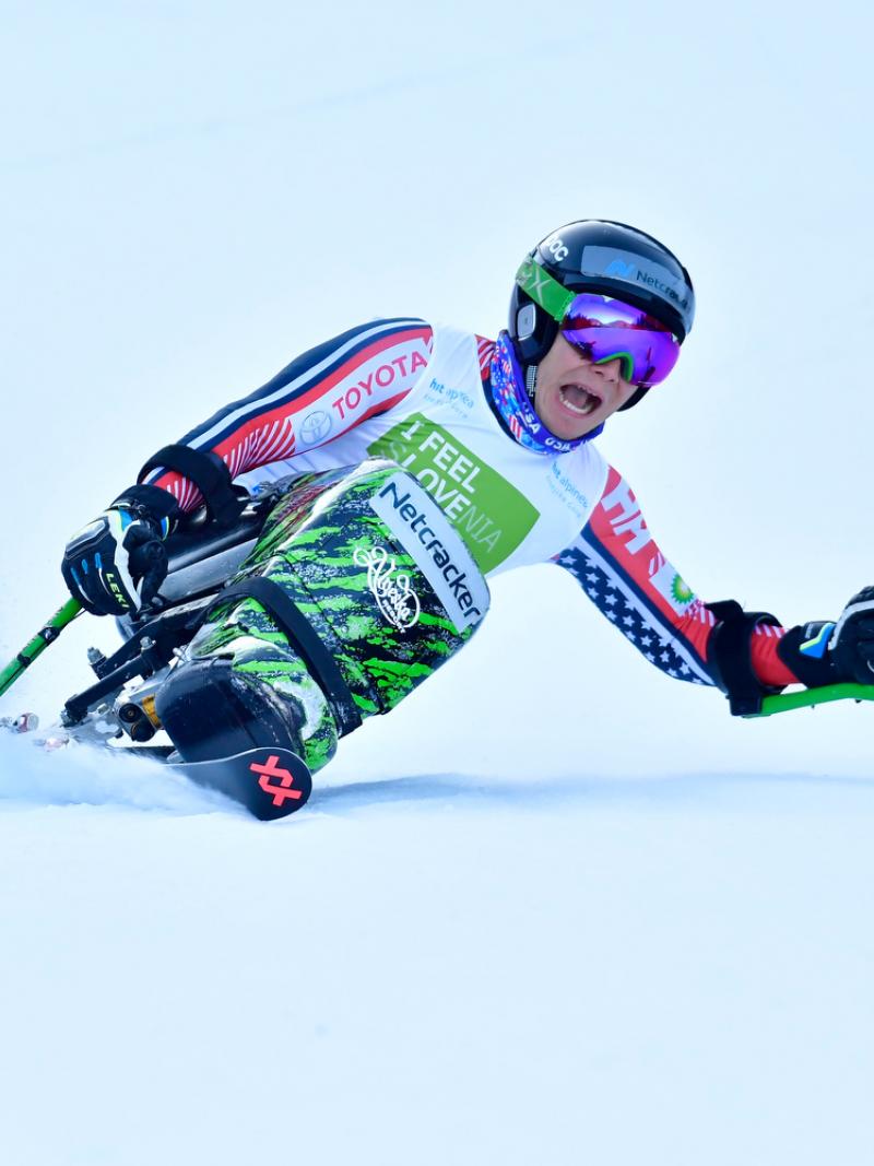 Male sit-skier makes a turn down the slopes