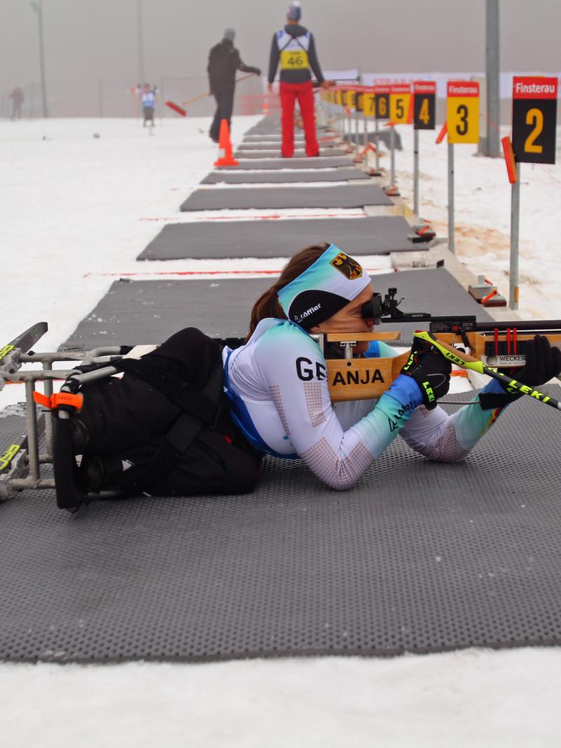 Female sit-skier focuses her rifle in biathlon