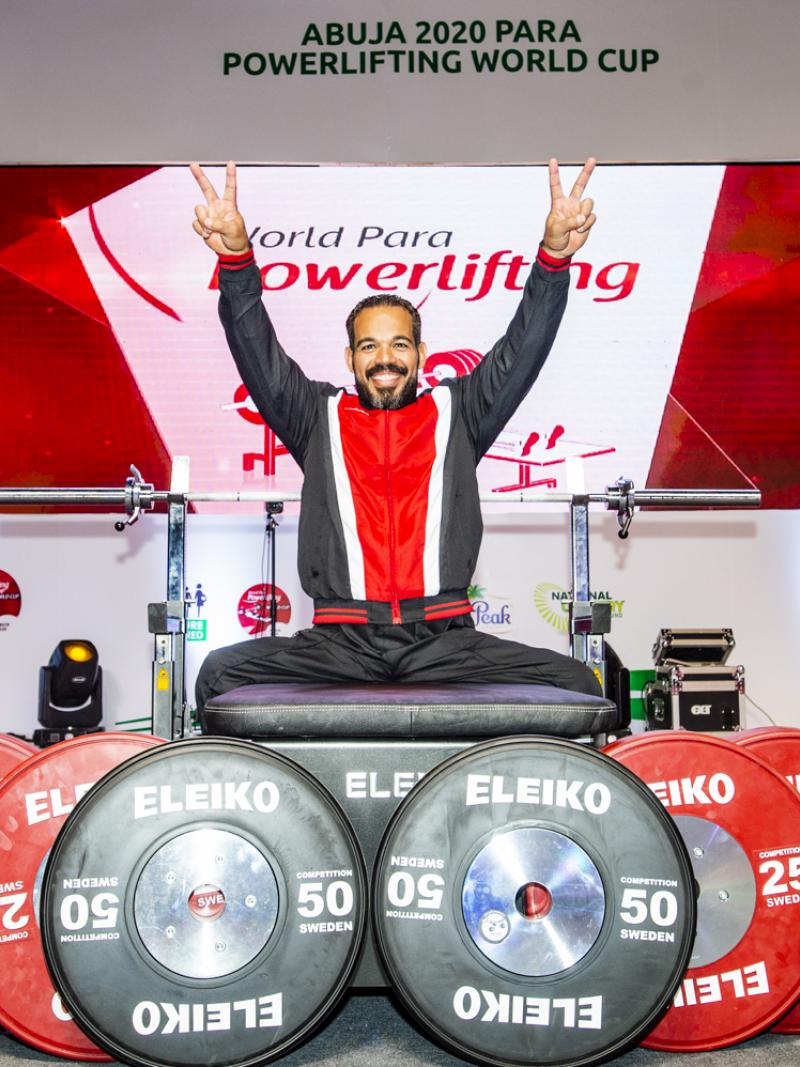 A man on a bench press with six discus in front of the bench