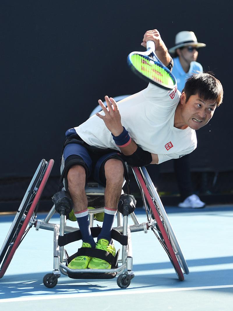 Japanese man in wheelchair hits a return shot in tennis