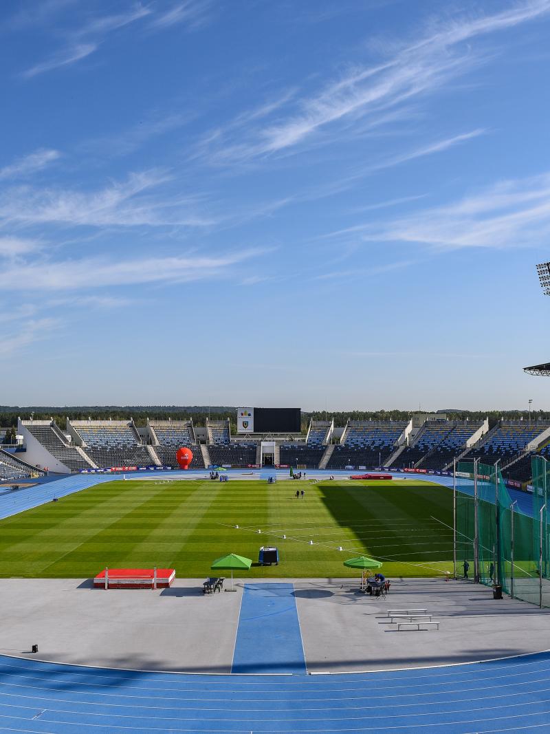 A stadium with a blue athletics track and field