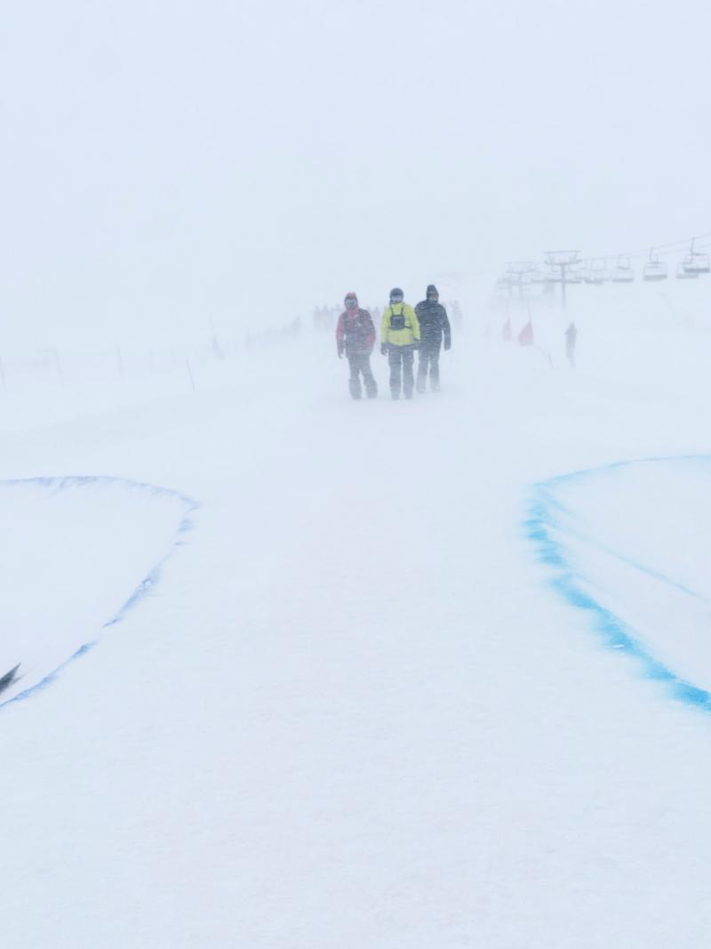 Two male Para snowboarders competing under heavy snowfall