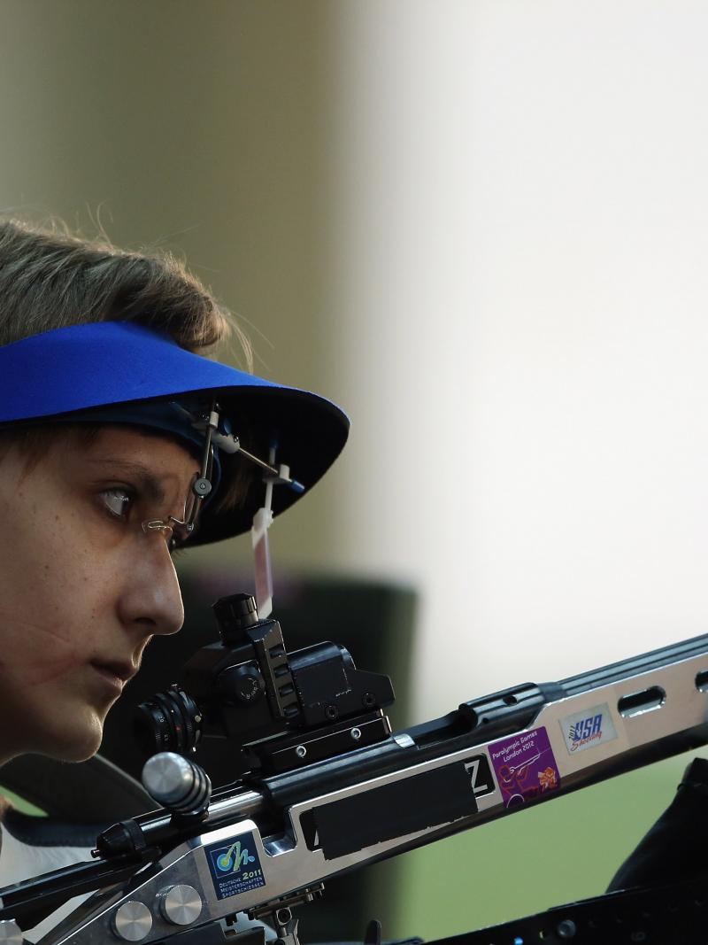 A woman holding a rifle in a shooting Para sport competition