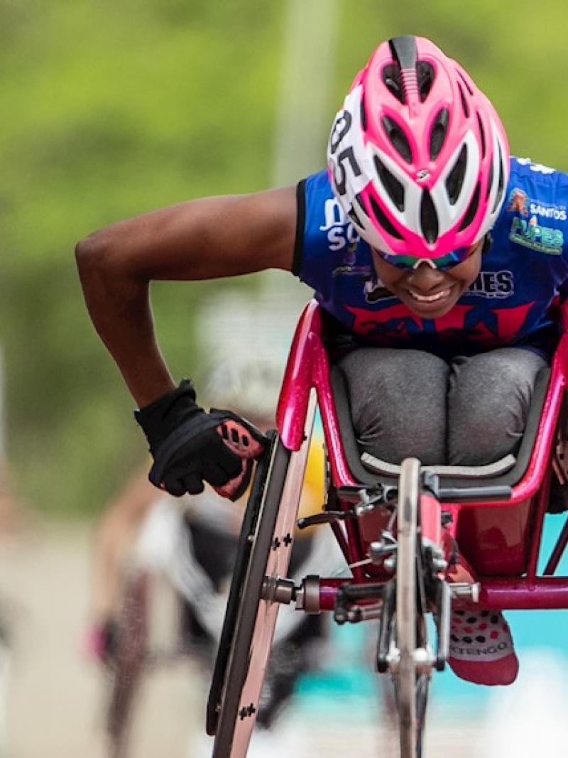 Vanessa Cristina de Souza pushing her wheelchair forward during a competition
