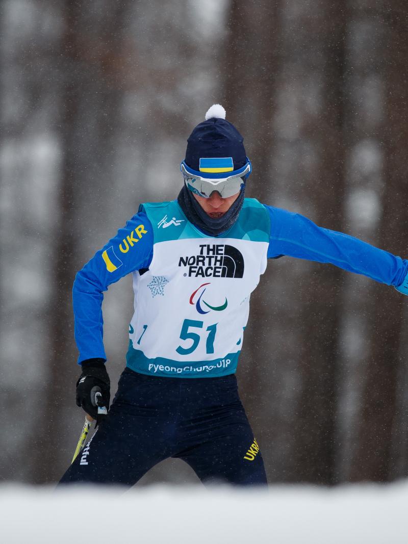 A female standing Para biathlete in the snow