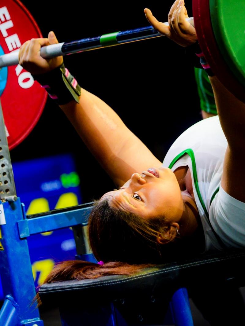 A female Para powerlifter preparing to lift the bar