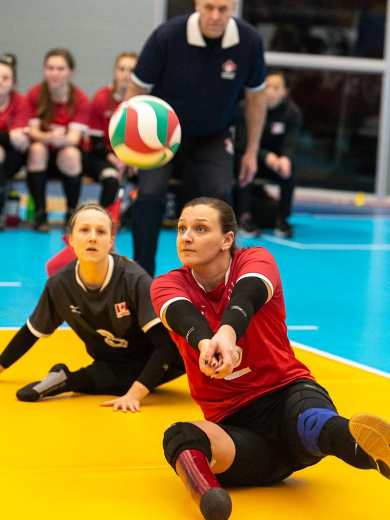 Female sitting volleyball player hits a bump