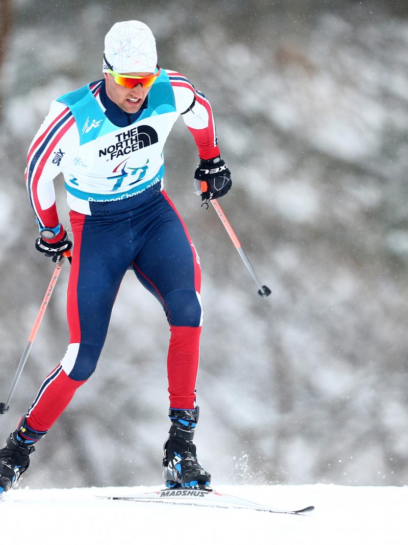 Norwegian male standing skier competes in biathlon