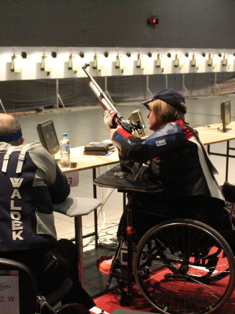 Four people in wheelchairs taking part in a shooting competition