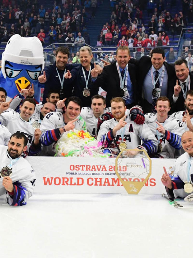 A group of men on an ice rink celebrating with their medals
