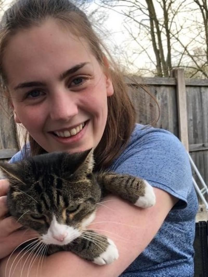 A young woman in a wheelchair holding a cat