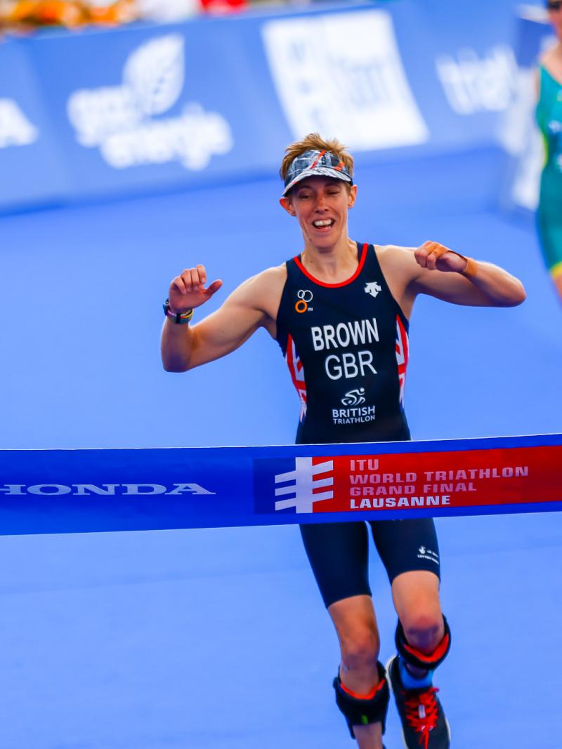 British female Para triathlete celebrates before she crosses the finish line
