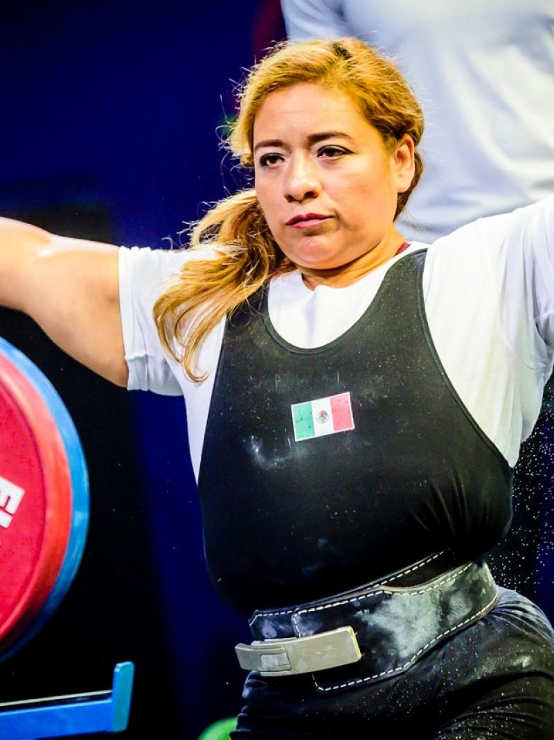 A woman stretching her arms before competing in a powerlifting bench press