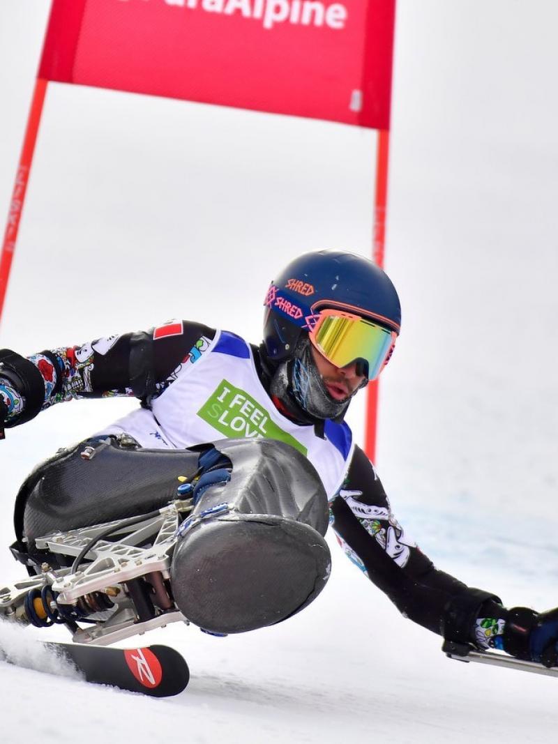 A male sit-skier competing on a giant slalom event