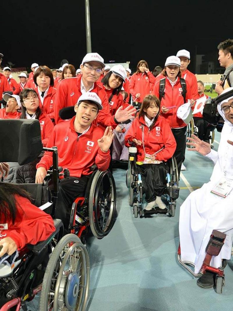 Japan delegation with man in wheelchair smiling with them