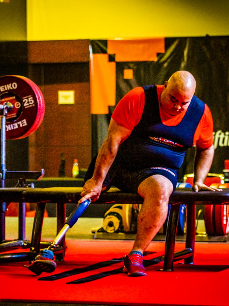 A man on a bench press in a Para powerlifting competition