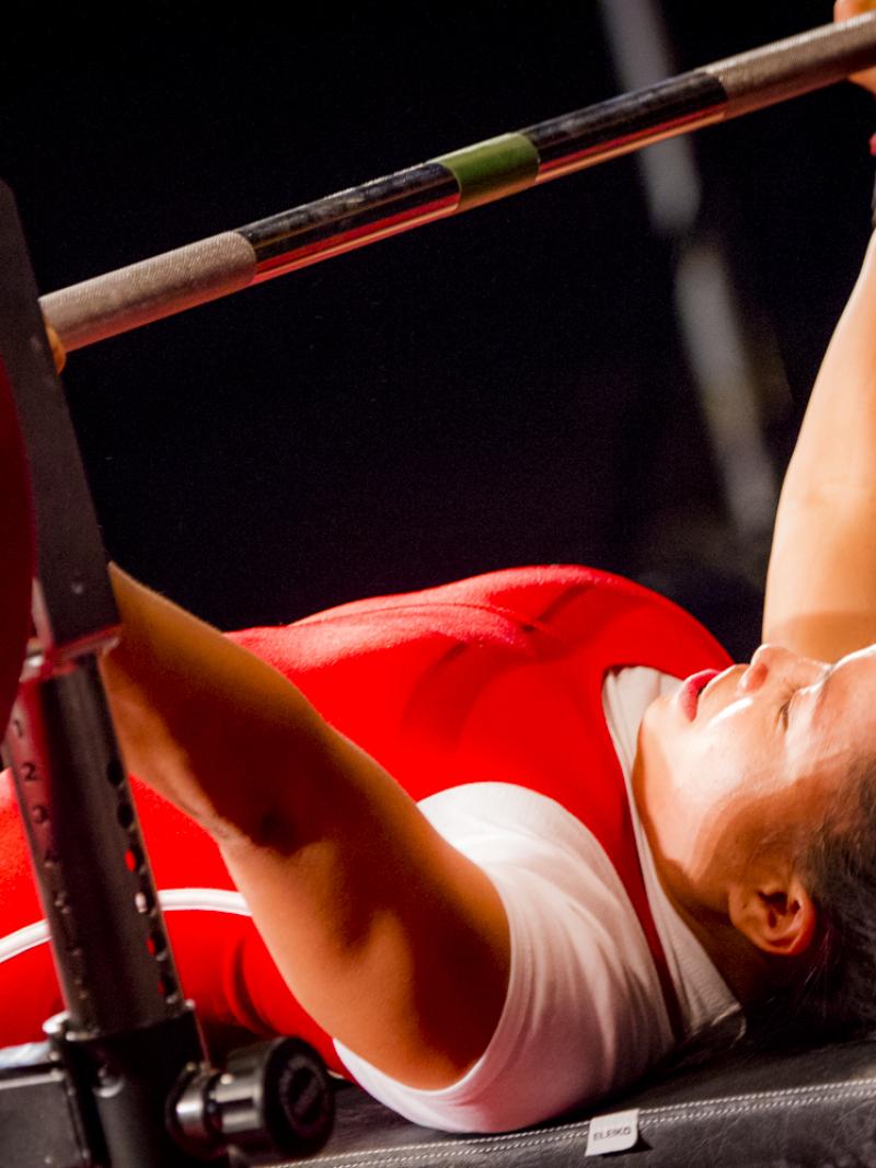 A woman preparing to lift a bar on a bench press
