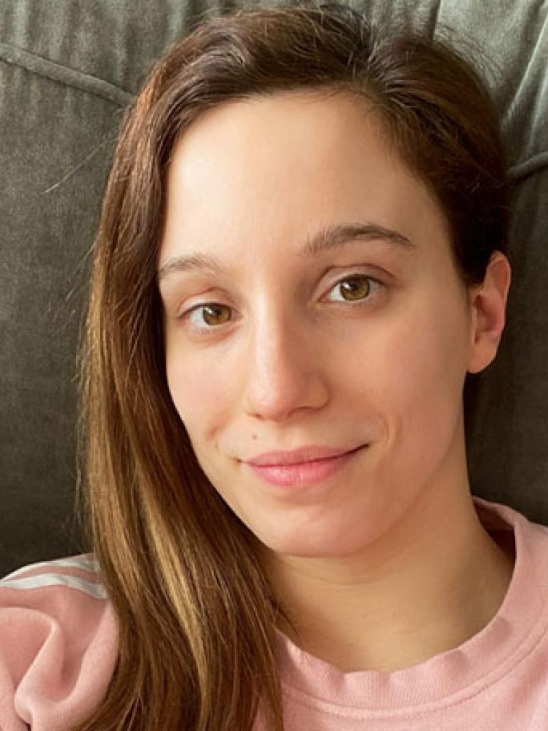 A woman wearing a pink shirt looking at the camera