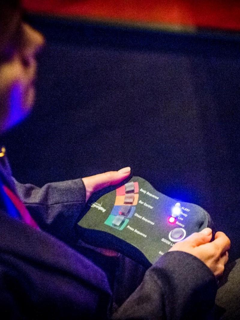 A woman with a control in her hand to judge Para powerlifting competitions