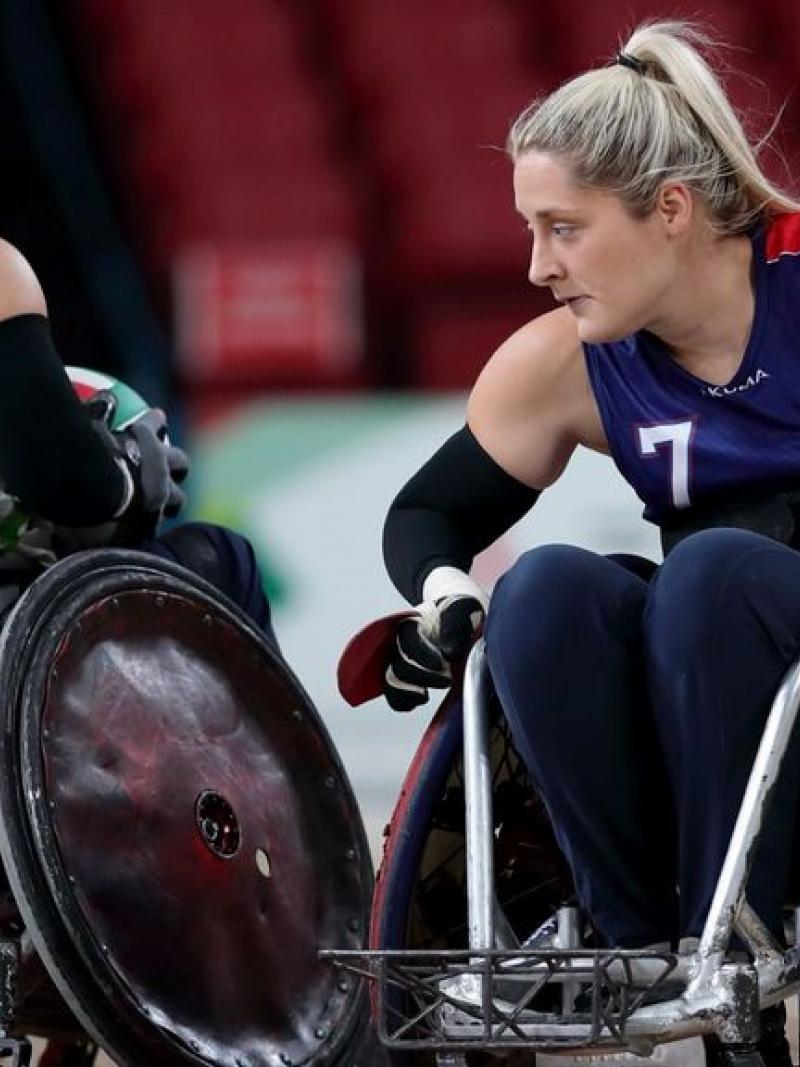 Female wheelchair rugby player stops an opponent
