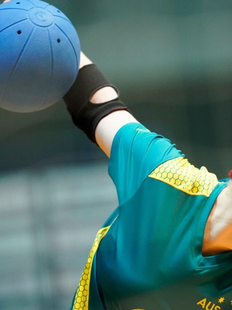 Female goalball player winds up to throw the ball
