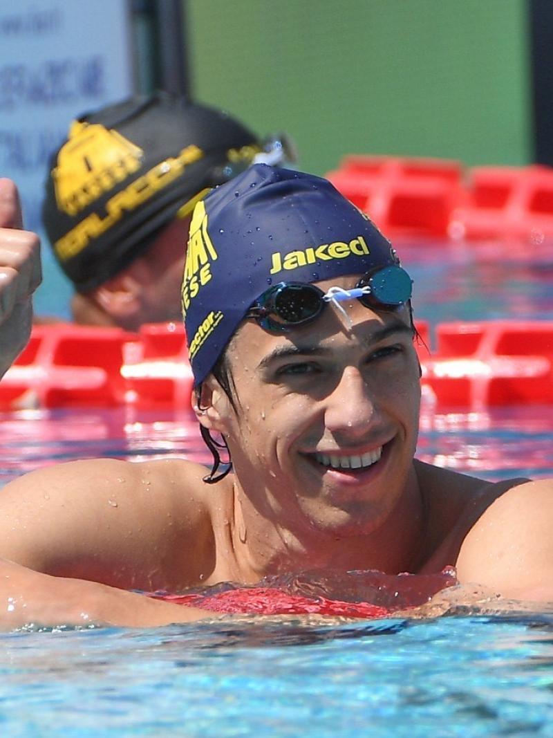 A male swimmer inside the pool giving thumbs up