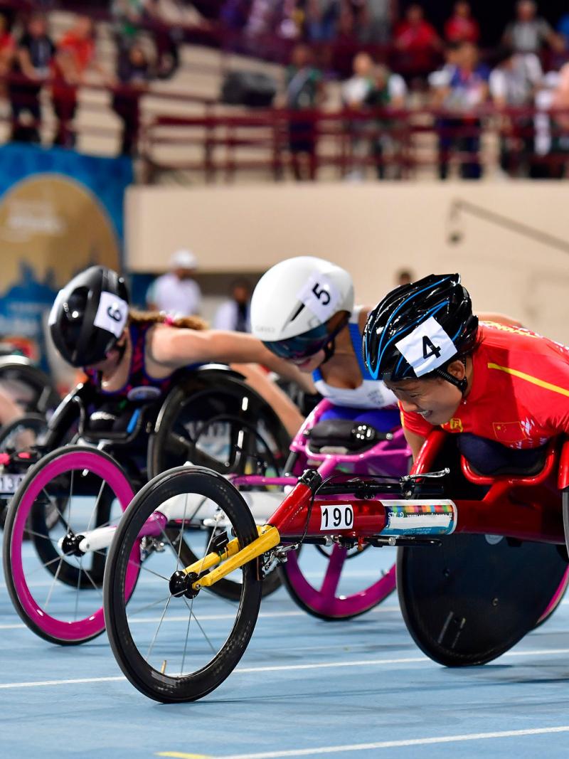 Four female wheelchair racers racing on the track