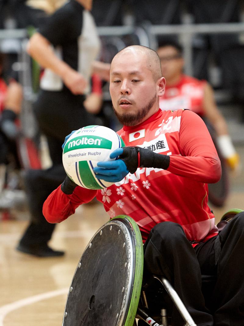 Male Japanese wheelchair rugby player holding a ball
