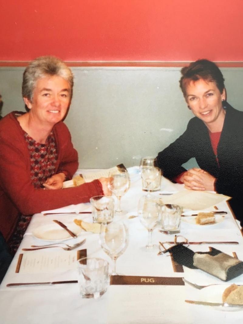 Photo of four people at a restaurant table smiling for a photo