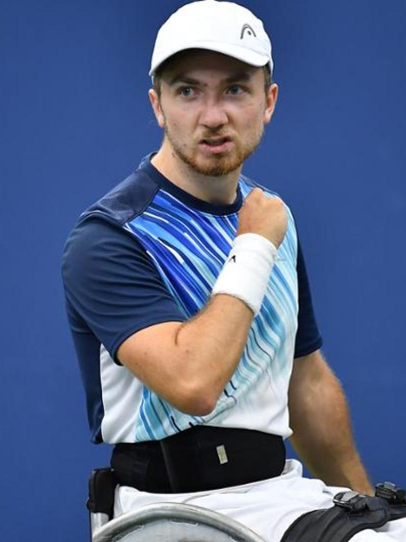 Dutch male wheelchair tennis player makes a fist after scoring a point
